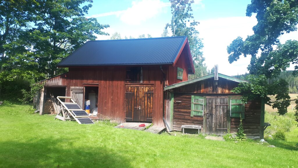 Off-grid solar panels outside an old barn