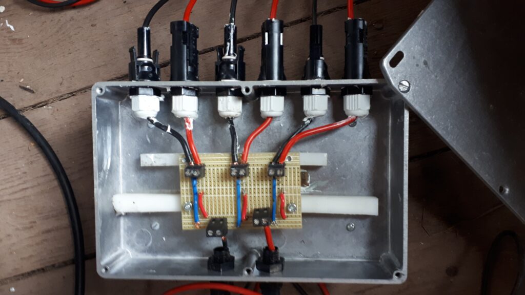 Homemade string combiner box interconnecting three off-grid solar panels